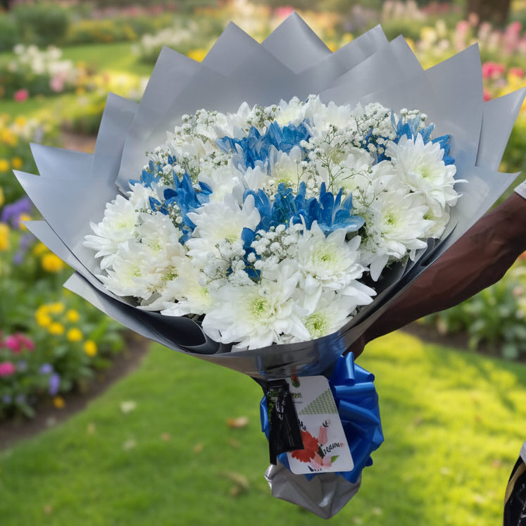Bouquet of white and blue flowers held by a person.