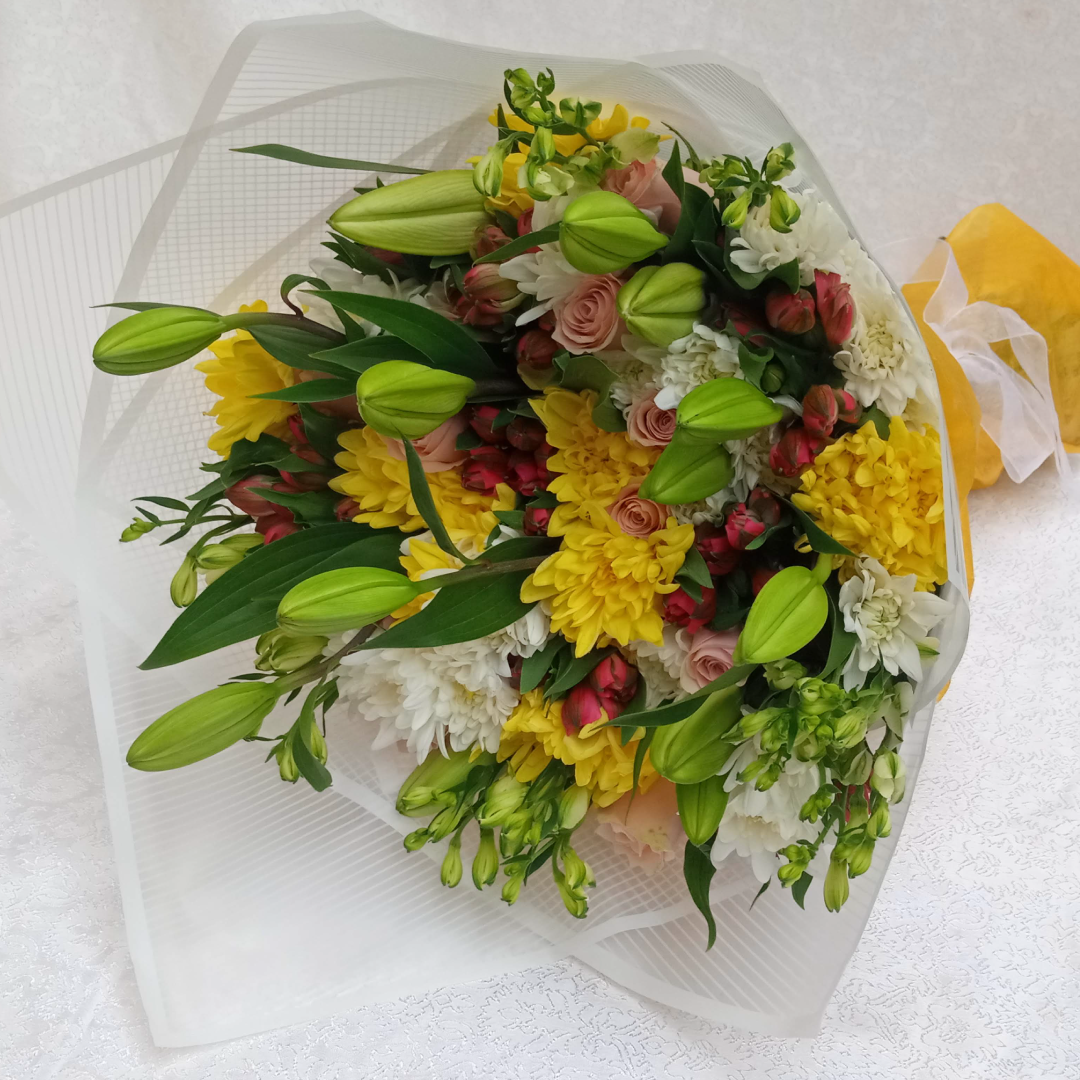 Amber Lily Bouquet by Simona Flowers Kenya, has a touch of: Lilies Hypericus flowers Yellow Chrysanthemums White Chrysanthemums With a side of flower fillers. The bouquet is wrapped with a complimenting wrapping material for the perfect occasion.