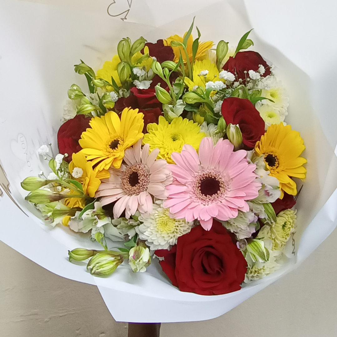 Gaberas Perfection Hand Bouquet by Simona Flowers Kenya, consists of: A variety of gaberas flowers Red Roses and Magnificent seasonal flower fillers