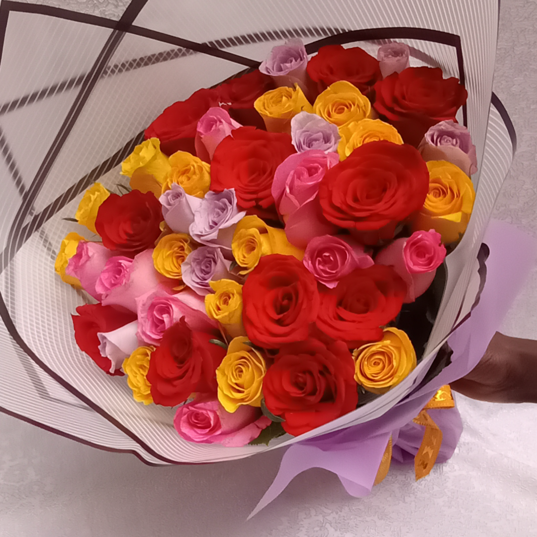 Nairobi Hand Bouquet by Simona Flowers Kenya, is a magnificent hand bouquet consisting of: Red Roses Pink Roses Lavender Roses Yellow Roses - perfect to use to brighten a loved ones day and to remind them just how special they are and how much you care for them.