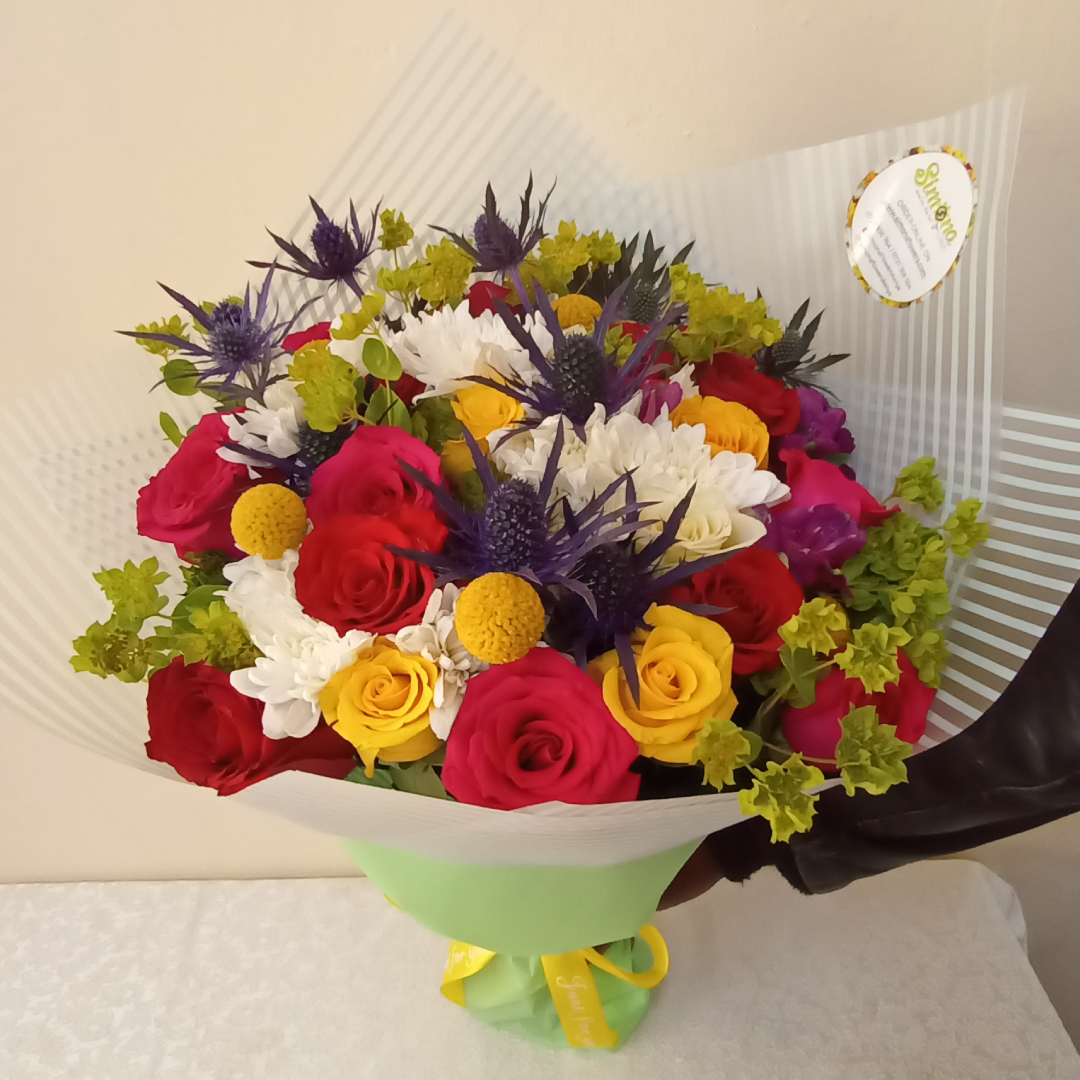 The Star Quality Bouquet by Simona Flowers Kenya, has a touch of: Yellow Roses Red Roses White Chrysanthemums and With tropical and seasonal flower fillers.