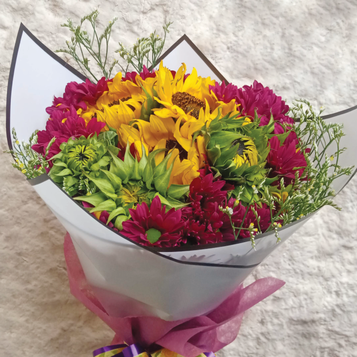 The Tropical Hand Bouquet by Simona Flowers Kenya, is a handcrafted bouquet of: Sunflowers Seasonal Flower Fillers and Gaberas Flowers