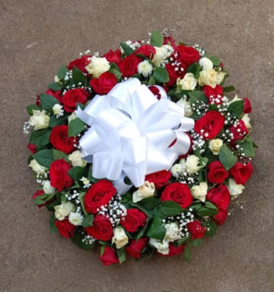 Standard round funeral wreath of white and red flowers by Simona Flowers