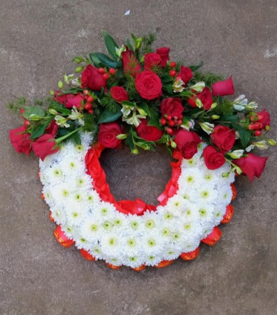 Executive red round shaped funeral wreath by Simona Flowers