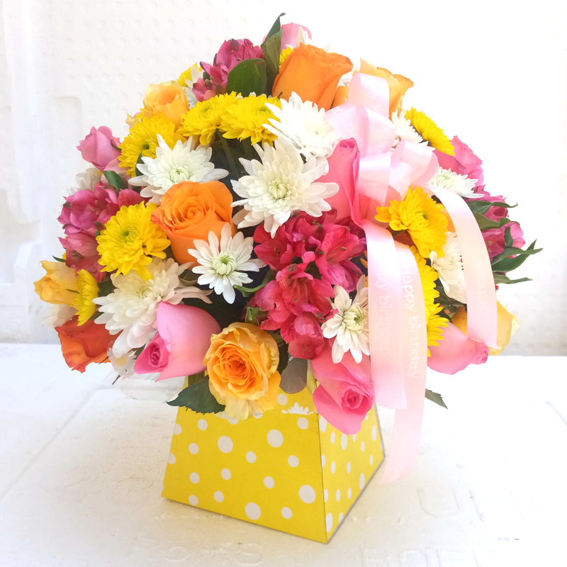 Bubbly Bouquet by Simona Flowers Kenya is An assorted bouquet of the royal box design brightly colored and ready for that surprise. It is arranged with : Pink Roses Yellow/Orange Roses Chrysanthemums Tropical Flower Fillers
