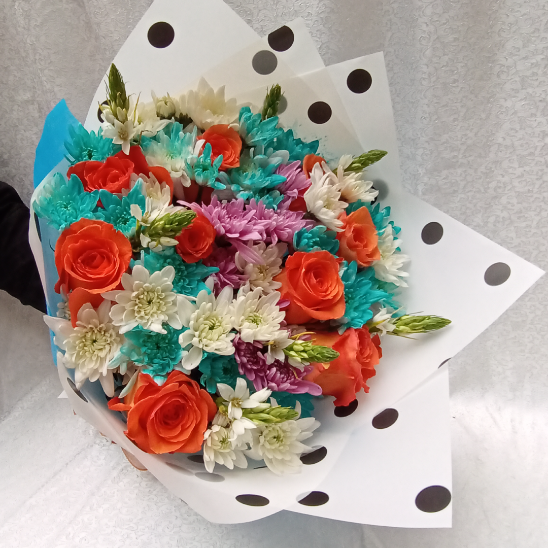 The Colorful Hand Bouquet by Simona Flowers Kenya,has a soft touch of;  Orange Roses Blue Chrysanthemums White Chrysanthemums Lavender Chrysanthemums and Seasonal beautiful flower fillers - best bouquet to offer as a gift to him (husband, boyfriend, father and son) during any special jubilant occasion.