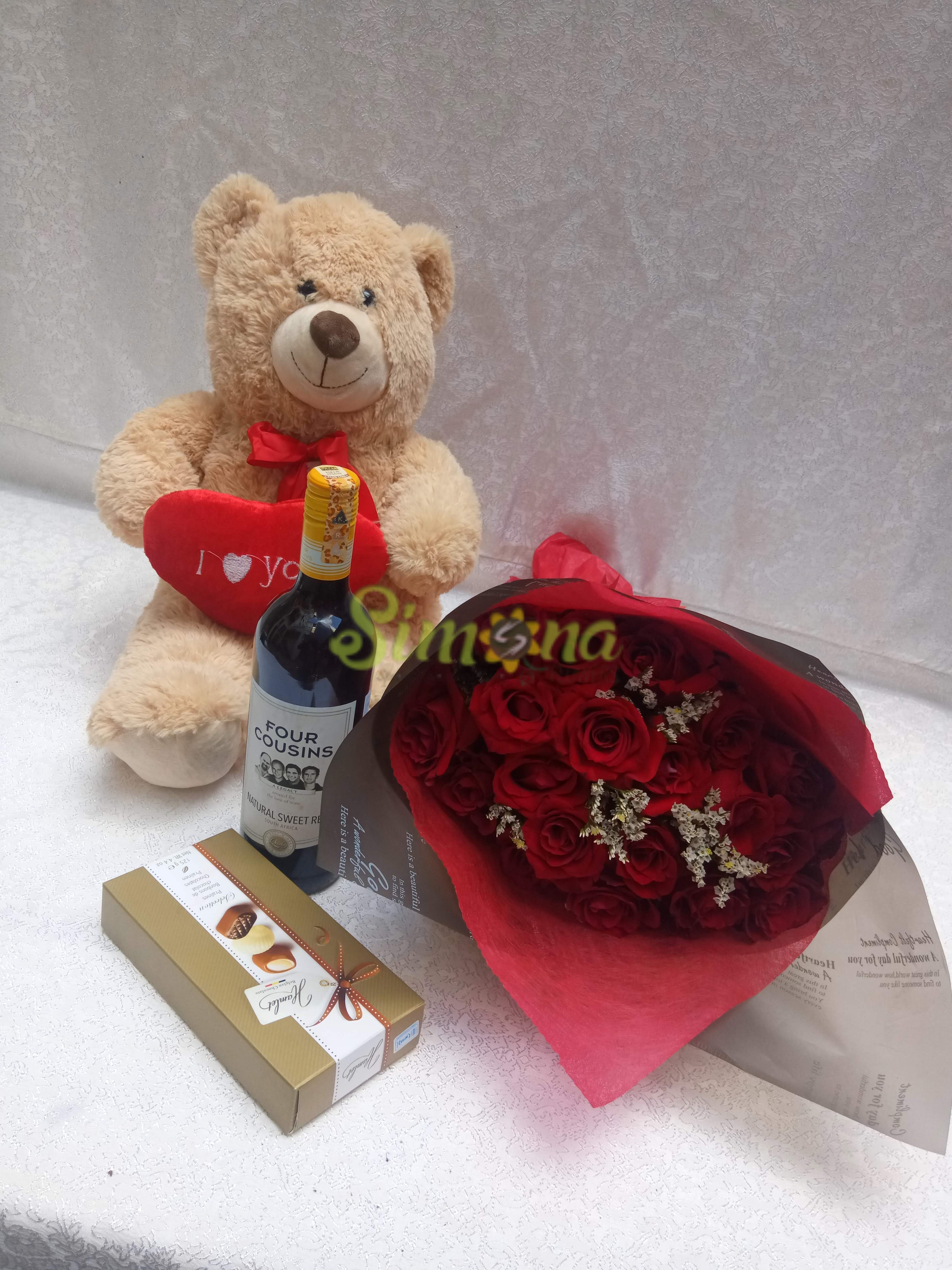 Delightful hand bouquet with teddy bear, red wine and hamlet chocolate