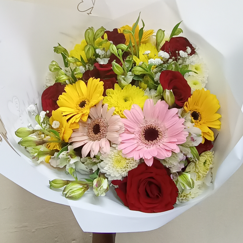 Gaberas Perfection Hand Bouquet by Simona Flowers Kenya, consists of: A variety of gaberas flowers Red Roses and Magnificent seasonal flower fillers 