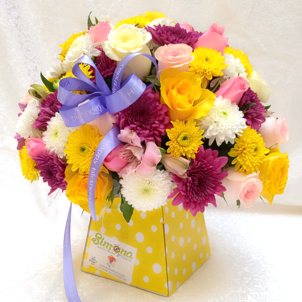 Assemble Bouquet by Simona Flowers Kenya, is a lovely vibrant arrangement with bright-colored flowers which includes:  White Roses Pink Roses Yellow Roses Yellow Chrysanthemums Lavender Chrysanthemums Alstroemeria