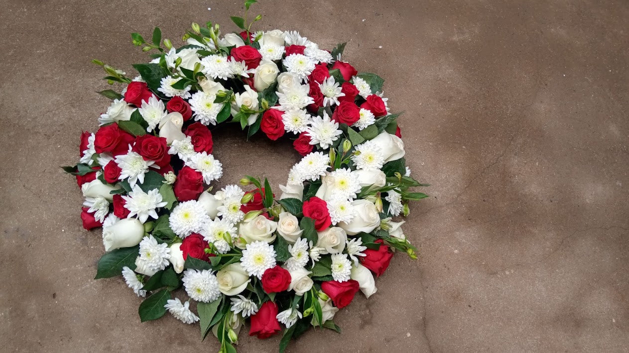 Corporate red round funeral wreath by Simona Flowers