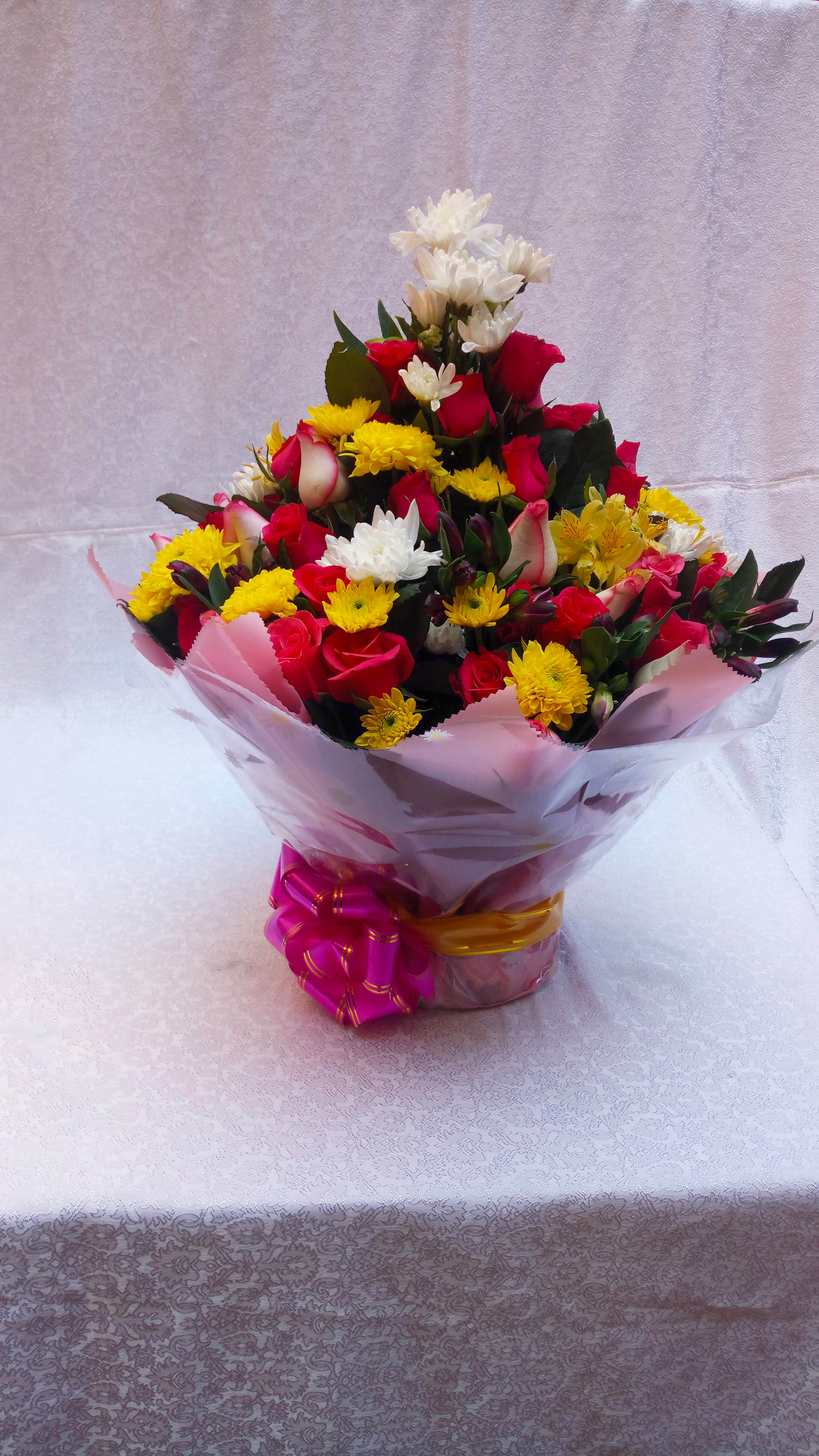 Water bouquet flower arrangement of chrysanthemums, a touch of roses and flower fillers