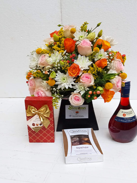 The full of joy package with A royal box flower arrangement, Red Robertson wine and two boxes of Guylian chocolates by Simona Flowers