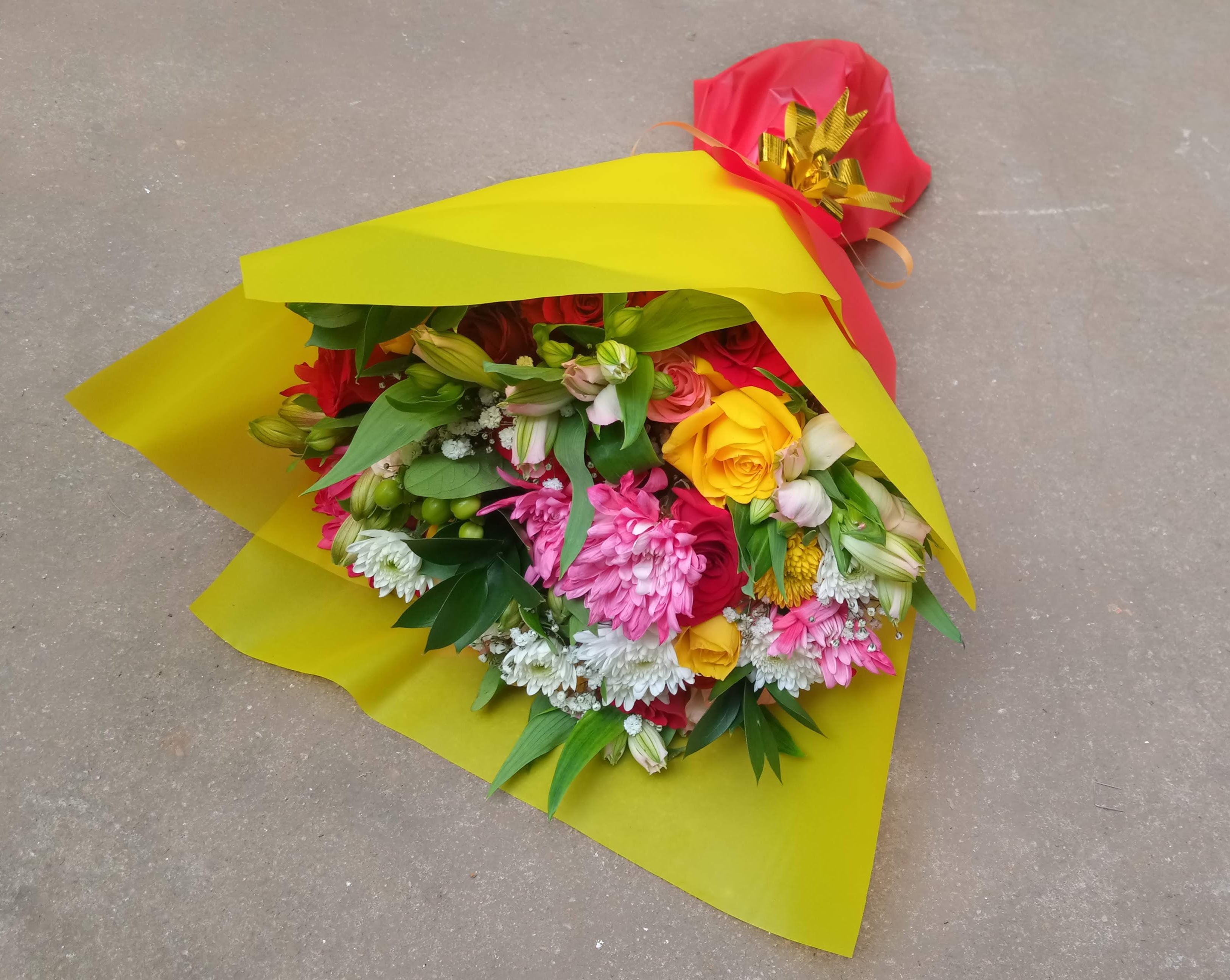 A hand bouquet of chrysanthemums and roses a touch of  with complimenting flower fillers by Simona Flowers