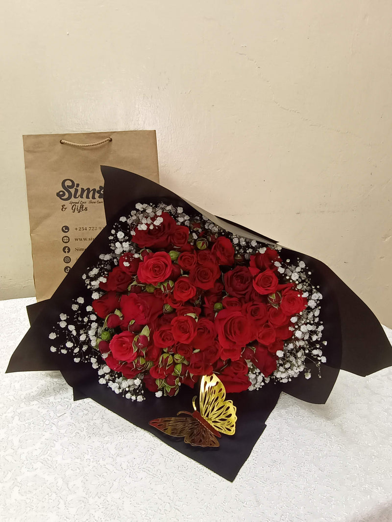 The red pomp bouquet is a nice red rose bouquet with a touch of gypsophila and a golden butterfly to lift your love into the air! - By Simona Flowers
